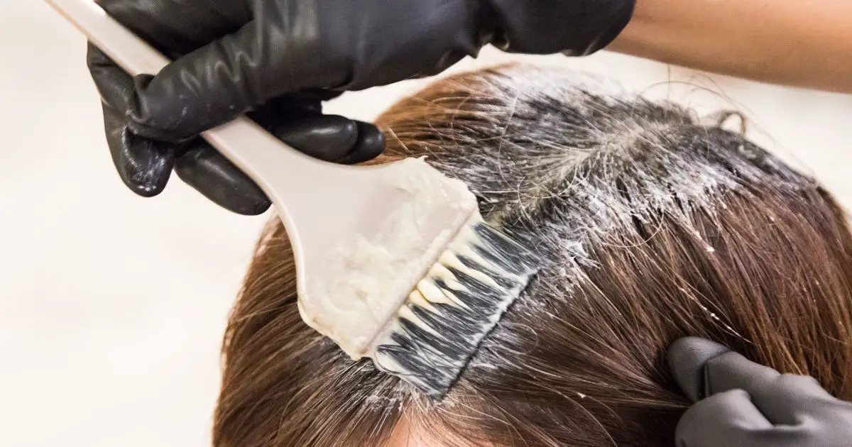 Hair dresser applying chemical color dye onto hair Hair dresser applying chemical color dye onto hair